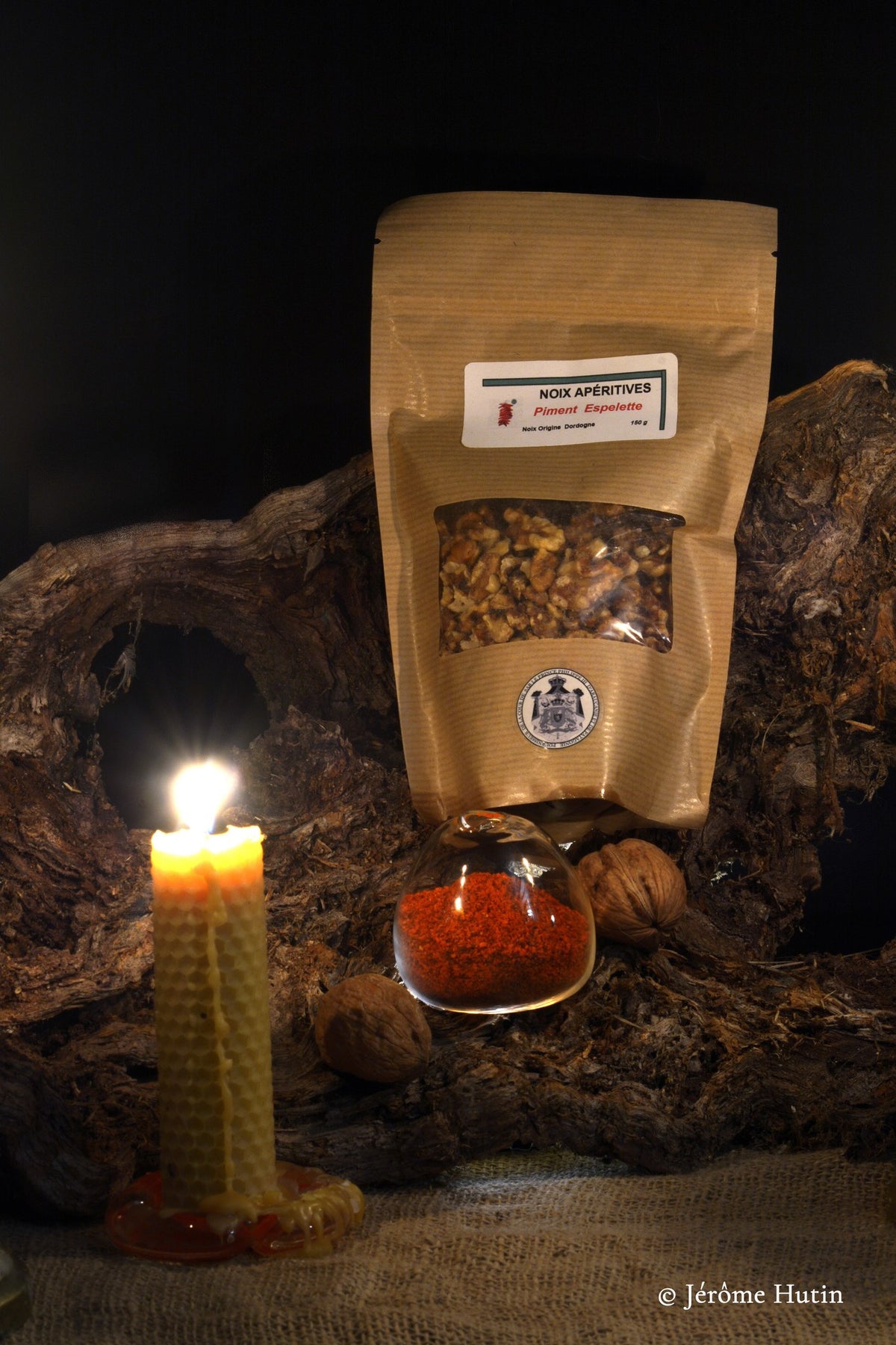 Sachet de cerneaux apéritifs au piment d'Espelette sur une souche de noyer, à la bougie Photo Jérôme Hutin.