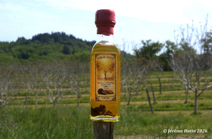 Bouteille d'huile de noix truffée posée dans le verger du Domaine du Noyer Photo Jérôme Hutin.